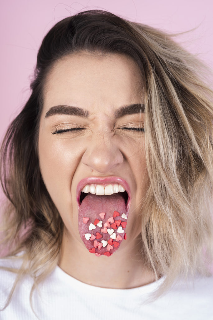 a girl with candy on her tongue